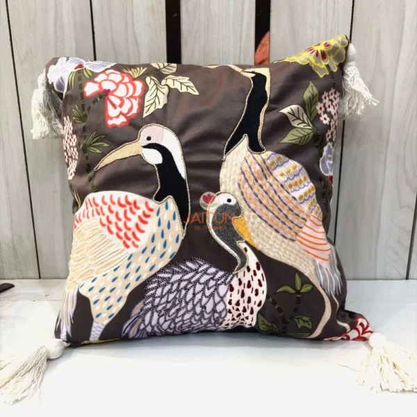 Crane Garden Cushion Cover with embroidered crane birds and floral garden motifs on brown fabric with tassel corners.