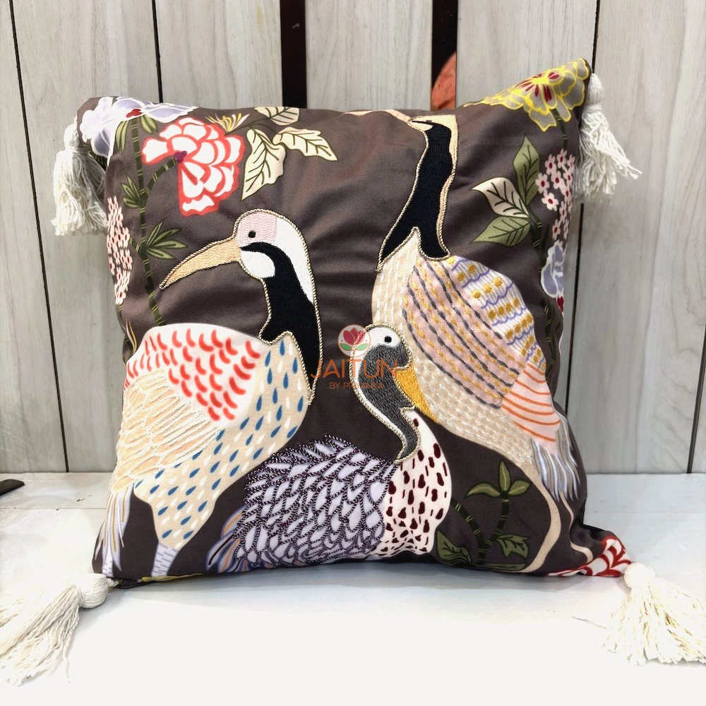 Crane Garden Cushion Cover with embroidered crane birds and floral garden motifs on brown fabric with tassel corners.