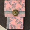 Blush Carnation Floral Double Bedsheet – Folded View Blush Carnation floral double bedsheet in soft pink with grey botanical print and decorative border