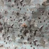 Cloud Petals Bedsheet – Floral Print Detail Close-up of Cloud Petals bedsheet showing large grey, ivory and dark floral motifs on a soft pastel blue base