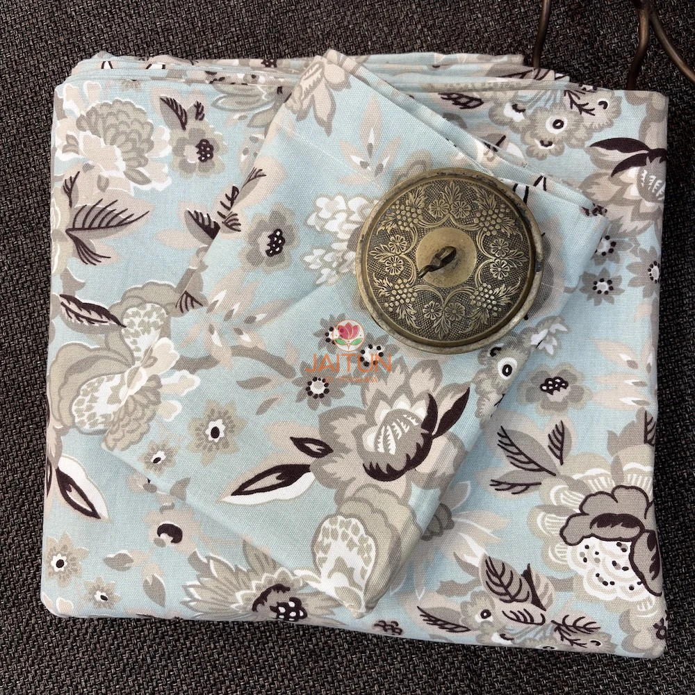 Cloud Petals Bedsheet – Folded Top View Top view of folded Cloud Petals floral bedsheet in pastel blue with coordinated grey and ivory botanical print by Jaitun