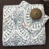 Folded Indigo Fern Bedsheet featuring an ivory base with elegant indigo botanical motifs