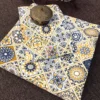 Folded Mediterranean Mosaic Bedsheet featuring navy blue and mustard tile-inspired prints