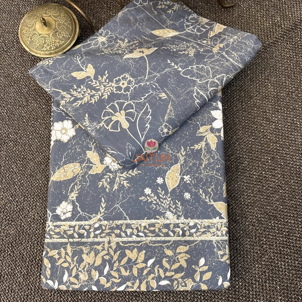 Folded Moonlit Meadow bed sheet showing slate blue floral pattern and decorative beige leafy border