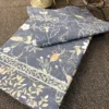 Moonlit Meadow slate blue bed sheet with delicate beige botanical print and leafy border detailing