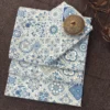 Moroccan Mist Bed Sheet folded and styled, showcasing blue and sage ornamental tile motifs